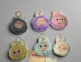 Set of colorful plush keychains with cartoon faces on a white background