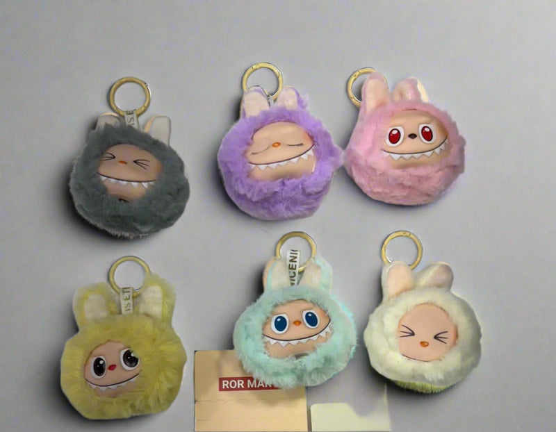 Set of colorful plush keychains with cartoon faces on a white background